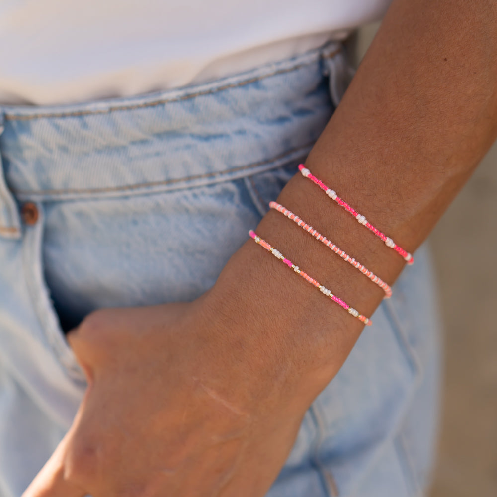 Handgemachtes pinkes Armbandset für Damen, drei filigrane Perlenarmbänder am Handgelenk, lässig zu hellblauer Jeans getragen. - Armbandset Karibik - Pink
