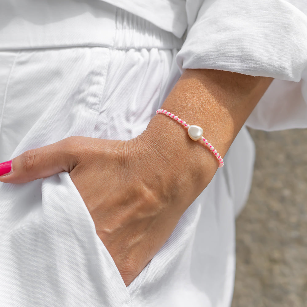 Handgemachtes pinkes Perlenarmband für Damen mit großer weißer Perle, getragen am Handgelenk zu weißer Kleidung. - Sommer Perlenarmband Maui Pink - Pink