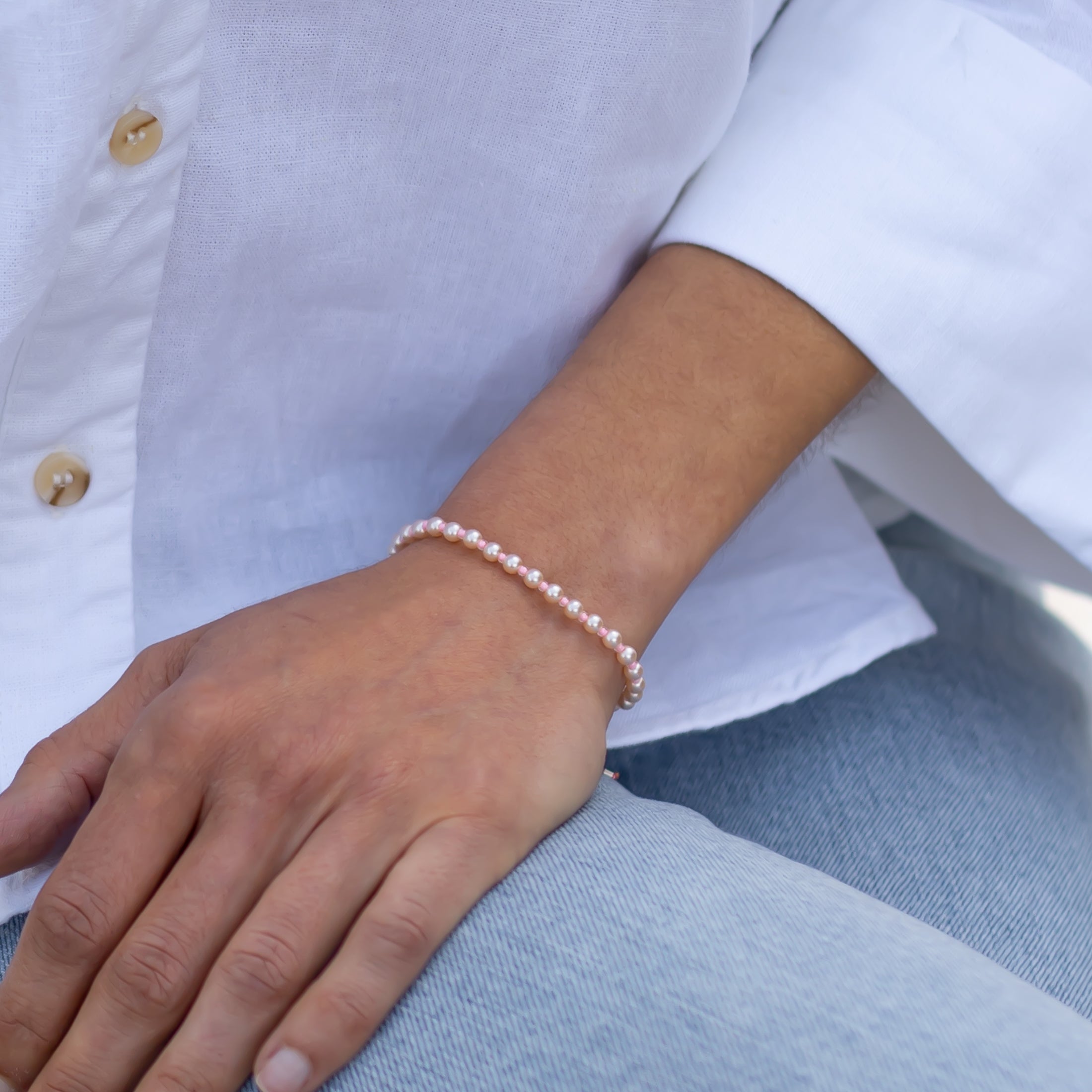 Handgemachtes pinkes Perlenarmband für Damen aus kleinen, glänzenden Perlen, getragen am Handgelenk zu weißem Hemd und. - Perlenarmband Rebell in luminous pink, orange, blau, rosa oder goldgelb - Apricot/Orange, Blau, Gelb, Pink