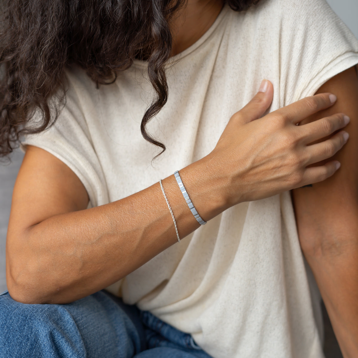 Graues Perlenarmband im Set mit einem Silberarmband für Damen.