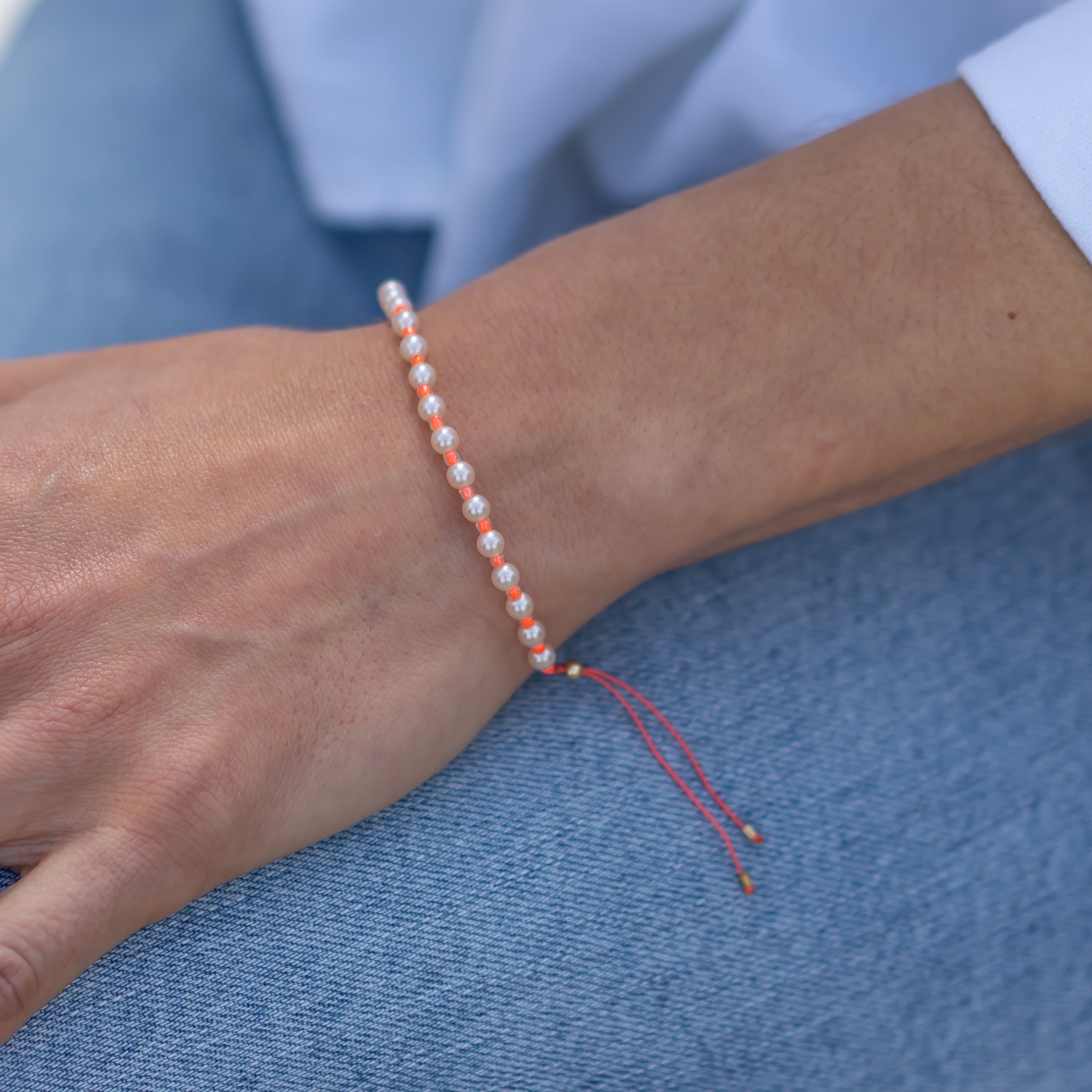 Handgemachtes Perlenarmband in leuchtendem Pink mit feinen goldgelben Details, Damenarmband am Handgelenk getragen. - Perlenarmband Rebell in luminous pink, orange, blau, rosa oder goldgelb - Apricot/Orange, Blau, Gelb, Pink